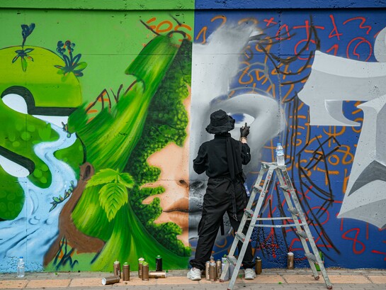 An artist creating graffiti on a wall