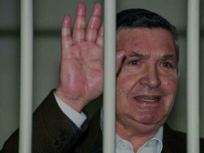 Salvatore Riina is behind bars and waving to get someone's attention