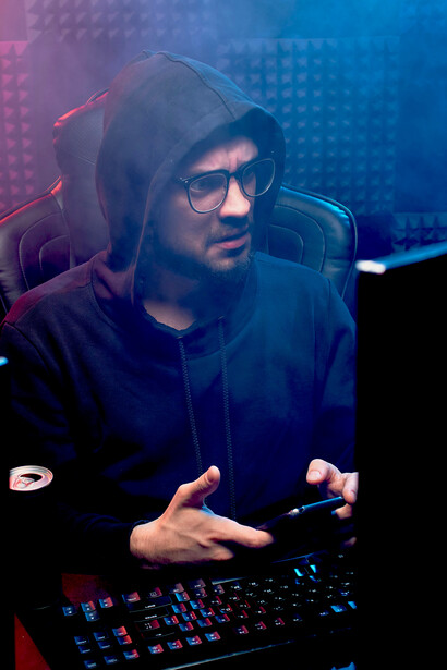 Alone at his computer, a man navigates the emotional toll of online spaces plagued by hate speech, cyberbullying, and social media harassment—key threats to digital dignity in today’s connected world