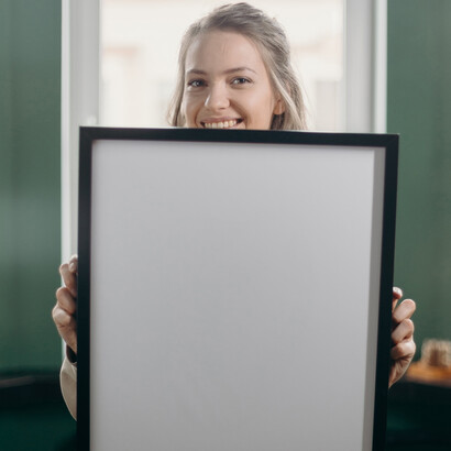 Minimal. Ragazza che sorride con in mano una cornice vuota