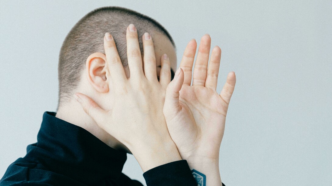 Pessoa envergonhada cobre o rosto