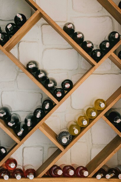 Wine bottles displayed on a rustic brown wooden shelf