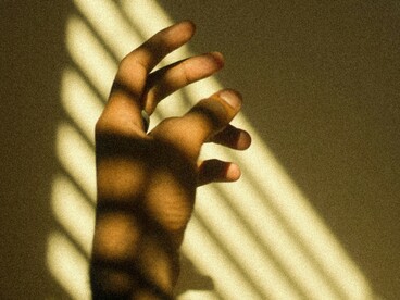 La même main, toujours traversée par des ombres et des lumières, est observée sous un autre angle