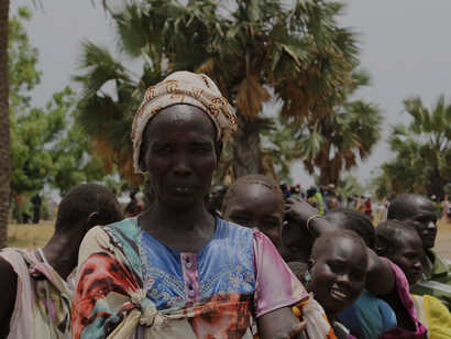 A woman waits at a temporary food distribution site in Leer, South Sudan