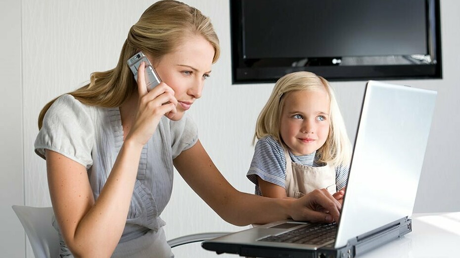 Una mujer trabaja desde casa junto a su hija