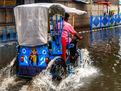 Man tricycles in rainy weather
