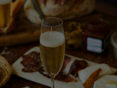 A picturesque display captures the essence of indulgence, featuring an artful arrangement of cured meats enhanced by the presence of a gracefully filled wine glass
