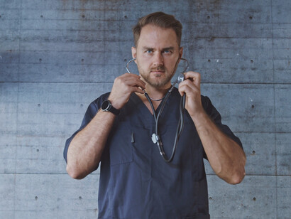 In a moment of quiet contemplation, a doctor embodies the struggle between hope and despair as he confronts the challenges of patient care within a flawed system