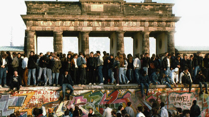 This Nov. 10, 1989 file photo shows Germans from East and West standing on the Berlin Wall in front of the Brandenburg Gate, one day after the wall opened