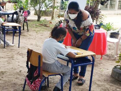 Educadora rural ayudando a sus alumnos