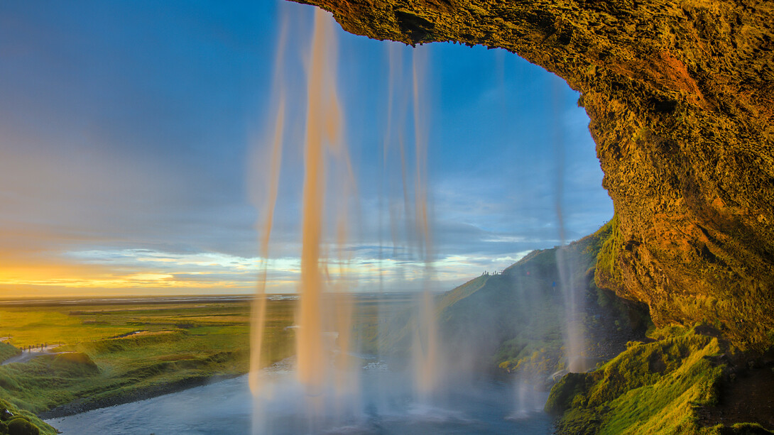 Vista lateral de la cascada Seljalandsfoss durante una puesta de sol, región de Suðurland, Islandia