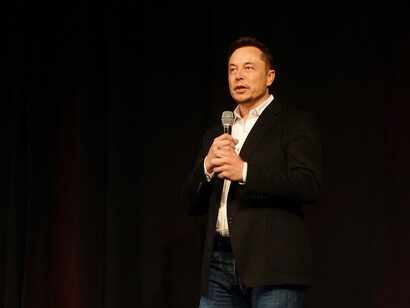 Elon Musk speaking to an audience at an event