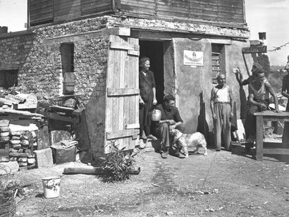 Gruppo di persone ritratte davanti a una baracca alla periferia di Milano, agosto 1948, particolare © Archivio Publifoto Intesa Sanpaolo