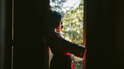 Silhouette of a woman in traditional attire by the window