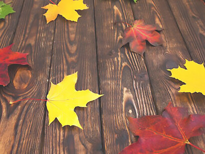 Colorful maple leaves on a brown wooden background