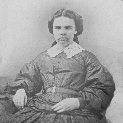 Sul mento e sulle braccia, Olive ricevette tatuaggi blu, simbolo di accettazione nella tribù