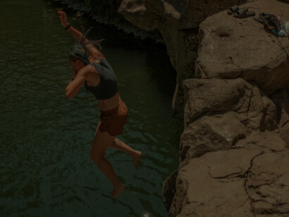 The girl takes the jump off the cliff into the cold river below