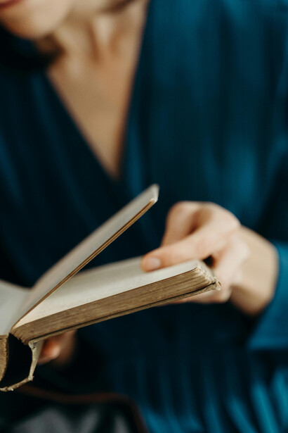Close-up of hands holding an open book, representing the depth of wisdom and accumulated experience