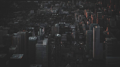 An aerial view of the city at night reveals a rare silence—its streets darkened by a widespread power outage