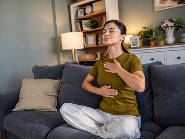 A woman practicing mindful breathing at home, illustrating the connection between the nervous system, emotional wellbeing, and the body