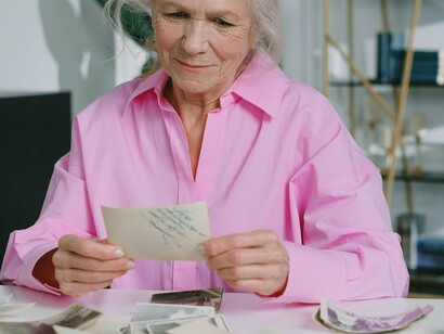 Mulher observa fotos antigas. Lembra do cafuné, da ternura, do amor de mãe. Isso ele lembra. Uma lembrança ofuscada pela dureza da vida e ação do tempo, mas ele lembra