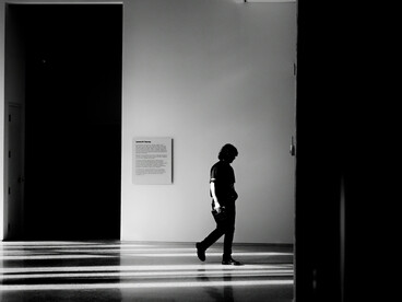 Black-and-white conceptual photography of a person surrounded by an expansive empty space, creating a striking atmosphere of solitude and introspection