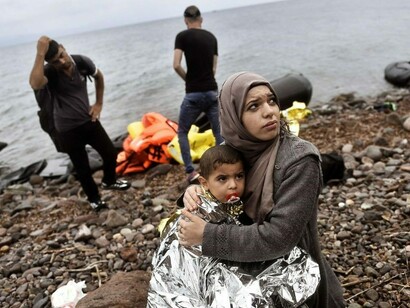 Una migrante siria con su hijo en las playas de Grecia