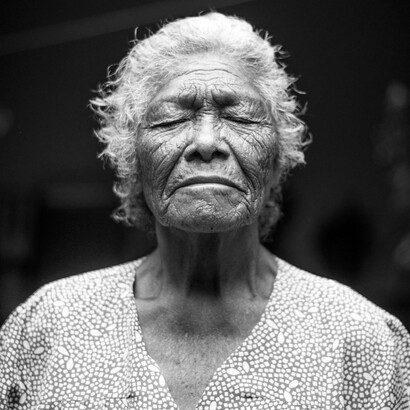 La anciana subía la cuesta, arrastrando en sus pies el peso de los años