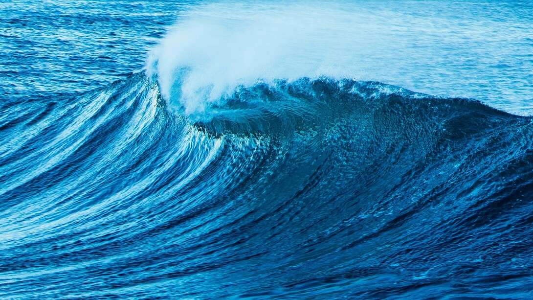 The roar of the tides: a powerful ocean wave curls and crashes, its deep blue waters shimmering under the light, reflecting both motion and depth, mirroring the ever-changing currents of thought and emotion