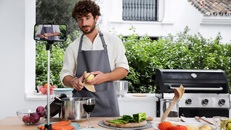 A male vlogger, live-streaming his cooking, exemplifies the impact of social media on culinary trends as a food influencer