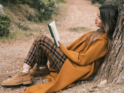 Tucked beneath a tree, she embarks on a journey more inward than outward, yet equally transformative