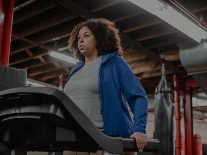 Mulher caminha na esteira de academia moderna