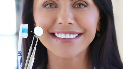 Smiling woman with bright white teeth, highlighting the importance of excellent oral health