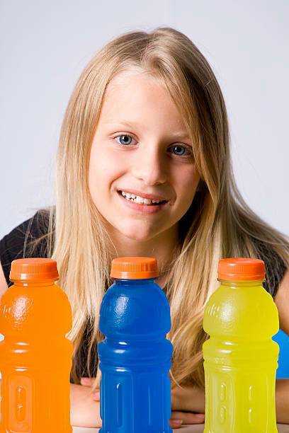 A teenager posing with energy drinks, showcasing the increasing trend of youth drinking these beverages despite potential health risks