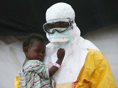 Un médico toma en brazos a un niño en Liberia