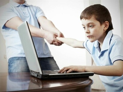 Un niño jugando con su ordenador portátil