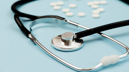 Stethoscope and pills arranged on a serene blue background, symbolizing the essential elements of modern healthcare and medical treatment