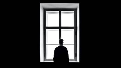 Hombre solitario mira por la ventana