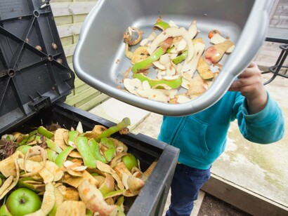 Tirando comida a un contenedor de basura