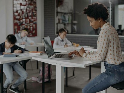 Insegnante svolge lavoro al computer nell'attesa che gli allievi finiscano l'esercizio assegnato