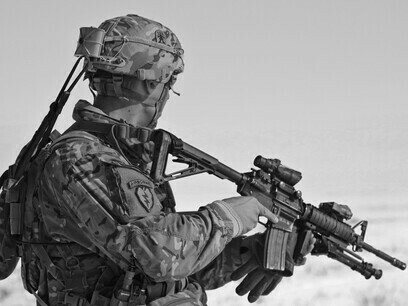 Ein Soldat, der sich darauf vorbereitet, sein Gewehr zu zielen. Er fängt die Essenz globaler Konflikte ein und beleuchtet, wie die sich verändernde internationale Machtdynamik Kriege anheizt und die sich ständig verändernde globale Ordnung gestaltet