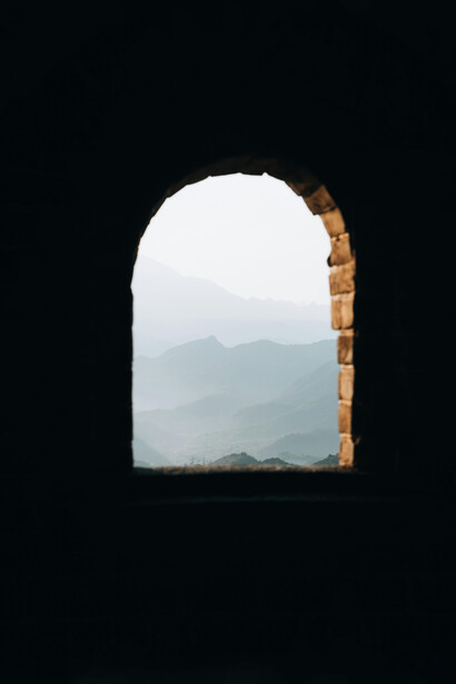Desde la penumbra de la habitación, la ventana enmarca un mundo en movimiento que no cesa de invocar al observador