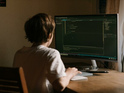 A young boy learning to code on a computer