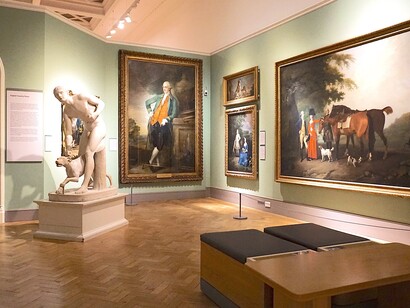 Exposição de quadros e esculturas em sala de museu