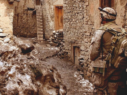 A soldier standing in a narrow alley during the Afghanistan war with the U.S. Marines, Afghanistan