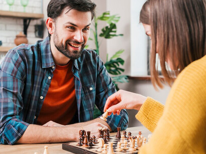 Husband and wife engaging in a thoughtful chess match at home
