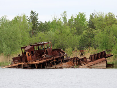 O desastre nuclear de Tchernóbil, ocorrido em 1986, causou um impacto profundo na saúde, no meio ambiente e na política global, com a Bielorrússia sendo uma das regiões mais afetadas. Rio Pripyat em Chernobyl, Ucrânia. Naufrágio abandonado após o acidente nuclear de 1986