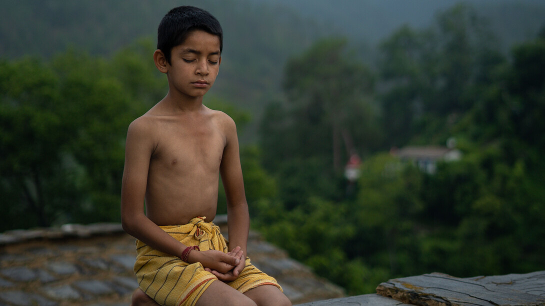 Pequeno garoto em conexão com a natureza ao meditar 