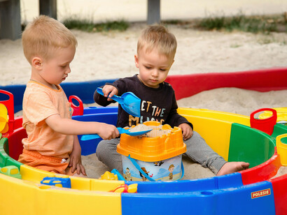 Children play together in the sand at a neighborhood playground