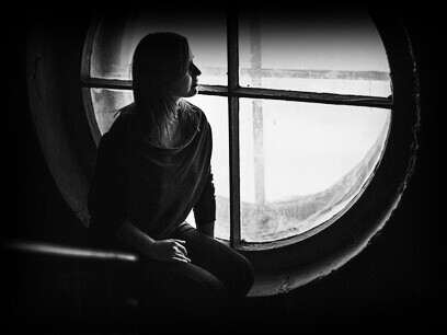 A woman sitting alone and feeling isolated, representing loneliness in a virtually connected world